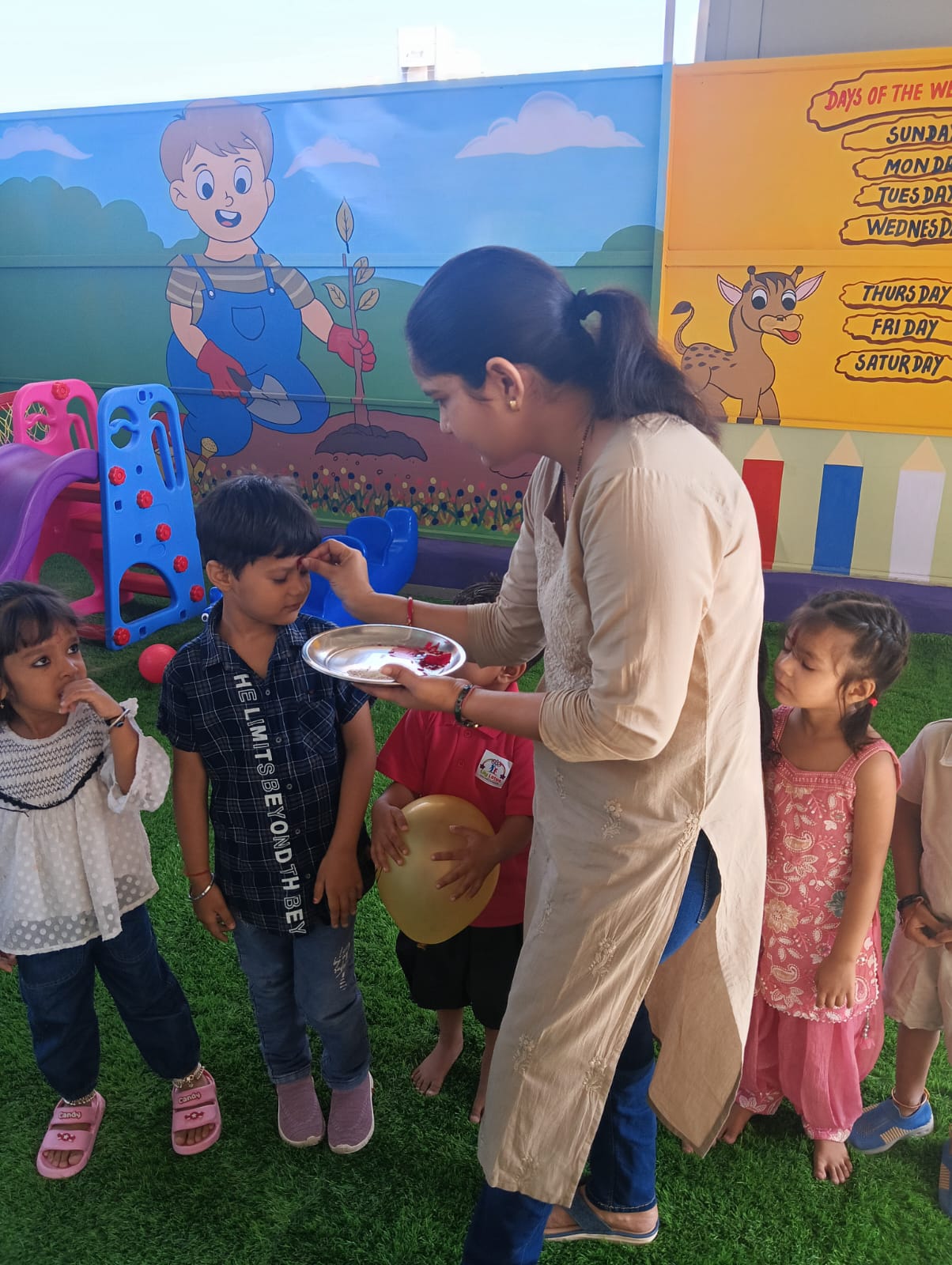 A student receiving a traditional tilak during a school celebration