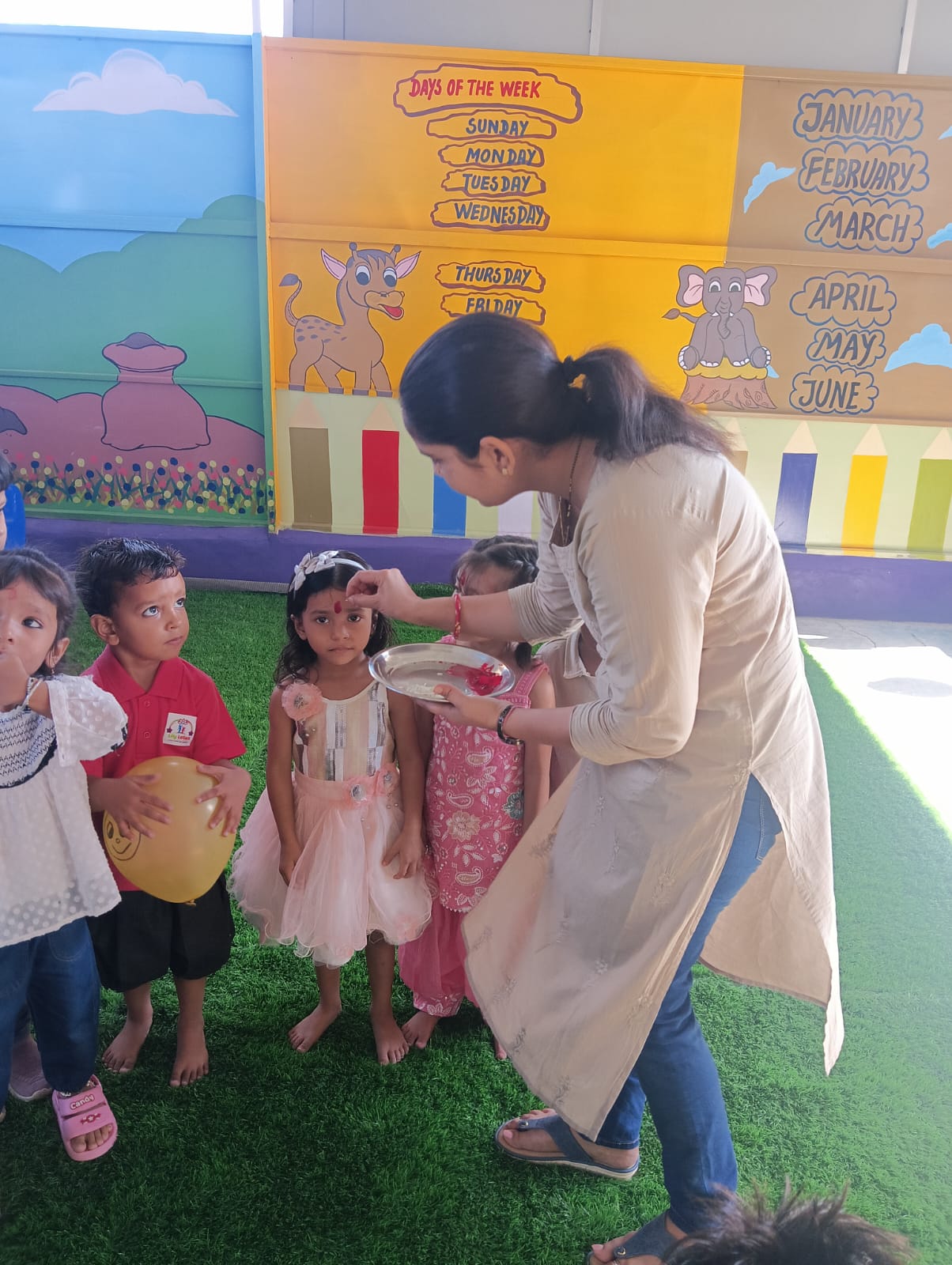 A student receiving a traditional tilak during a school celebration